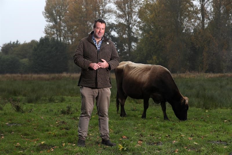 Stuart Roberts stood in front of a cow