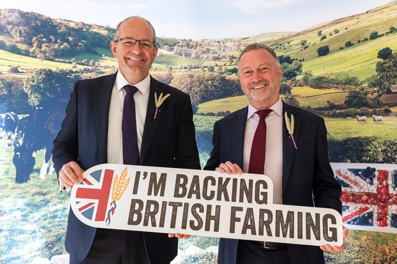 NFU President Tom Bradshaw and Defra Secretary of State Steve Reed at parliamentary reception holding a Back British Farming sign, smiling