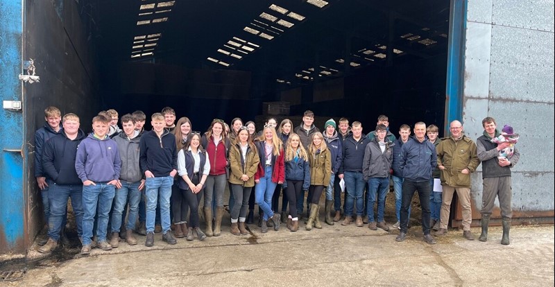 Photo of a group of Kendal College students stood outside a barn at Richard Ladds farm in Cumbria 