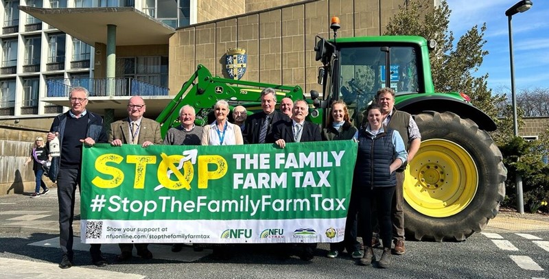 NFU members stood outside Durham County Hall with a Stop The Family Farm Tax banner and a tractor