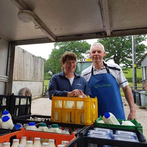 Dennis and Heather Newton loading milk