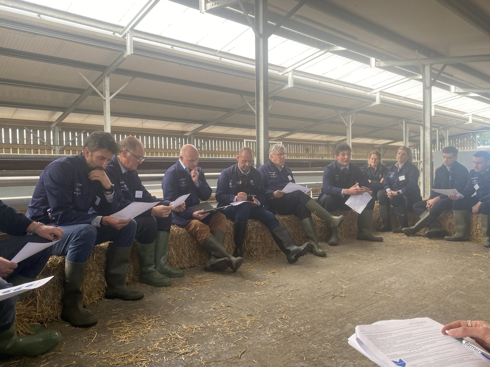 Farmers sat reading papers in a barn